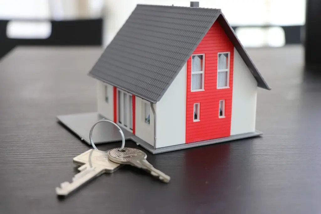 Kleines Modelhaus mit Schlüsselbund als Symbolbild für schlüsselfertige Immobilien